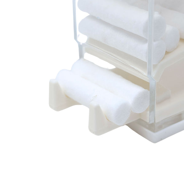 White plastic cotton roll dispenser holds dental cotton roll